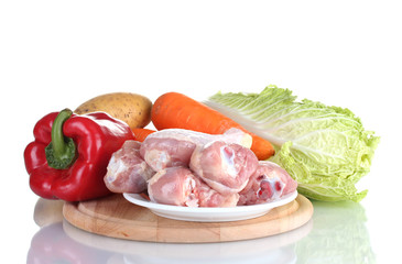 Fresh vegetables with raw chicken drumsticks