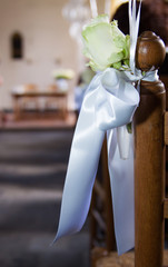 Wedding bow with a white rose on a chair