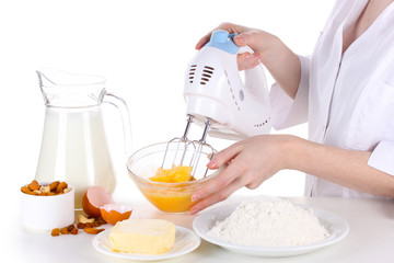 Female hands mixing eggs in bowl isolated on white