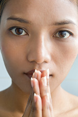 Closeup portrait of a young woman praying