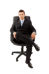 Young business man sitting in a chair and relaxing, isolated on