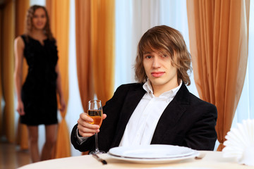 Young handsome man sitting in restaurant