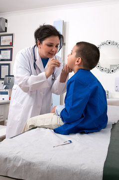 Pediatrician Examining Child’s  Throat With Tongue Depressor