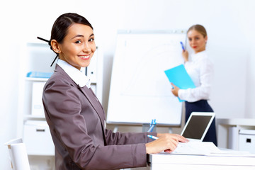 Obraz premium Young woman in business wear working in office