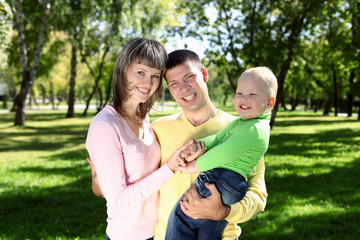 Fototapeta premium Young family with a child in summer park
