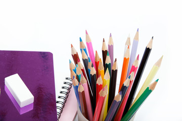 Fototapeta premium Coloured pencils and notebooks on a white background.