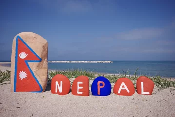 Foto auf Acrylglas Nepal Nepal on colourful pebbles with flag on the beach
