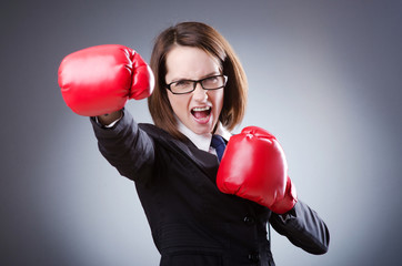 Young businesswoman in boxing concept