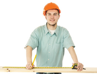 A young construction worker measuring , isolated on white
