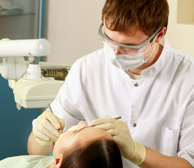 A dentist curing woman teeth