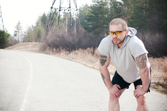 A male runner pauses during his run
