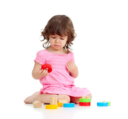 Funny little child playing with colorful toys, isolated over whi