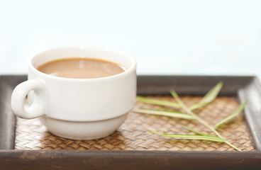A cup of coffee on wood tray