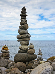 high stack of pebbles on the beach and sea background