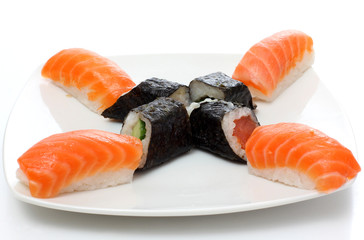 Black rolls and red sushi on plate