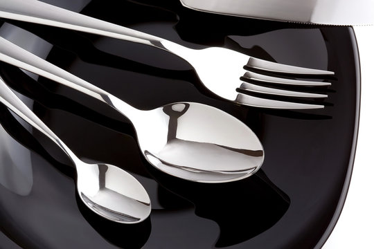 silver fork, knife and spoon as utensils on plate