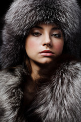 Beautiful young girl in fur clothes. Studio shot