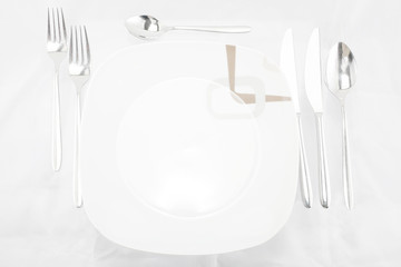 Plates with a silver fork, spoon, dessert spoon and a knife