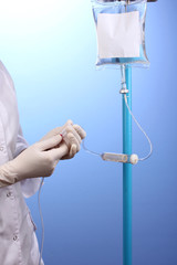Nurse doing infusion on blue background