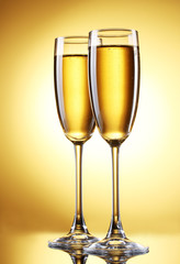 glasses of champagne on yellow background