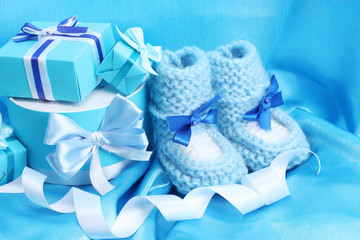 beautiful gifts and baby's bootees on blue silk