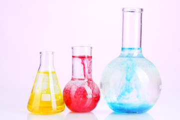 brightly ink in a flask with water on pink background