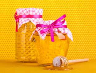 Jars of honey and wooden drizzler
