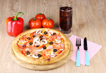Aromatic pizza and cola on wooden background