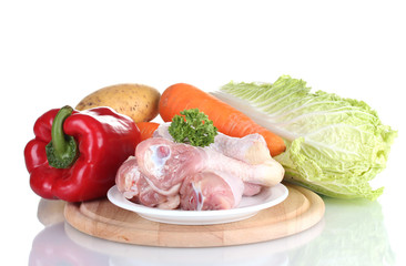 Fresh vegetables with raw chicken drumsticks