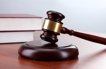 gavel and books on wooden table on gray background