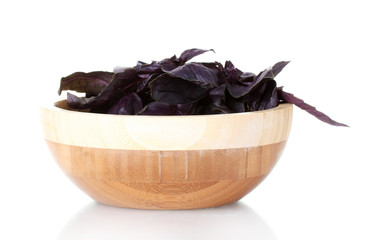 Basil in a wooden bowl isolated on white