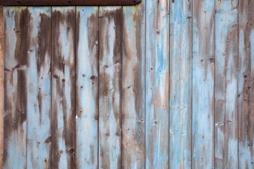 Verwitterte tuerkisfarbene Bretter eines alten Holztores