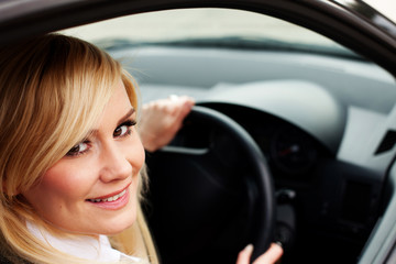 Naklejka na ściany i meble Uśmiechnięta kobieta w sterownik kierownicą samochodu