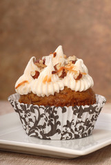 Delicious carrot cake cupcake with cream cheese frosting and nut