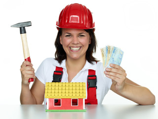 Pretty girl with money, helmet and hammer for building a house