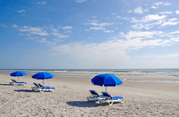 Row of Beach Chairs with Blue Umbrellas