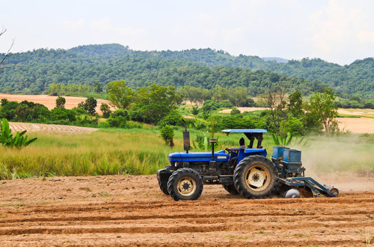 The Blue Tractor Working On A Field .