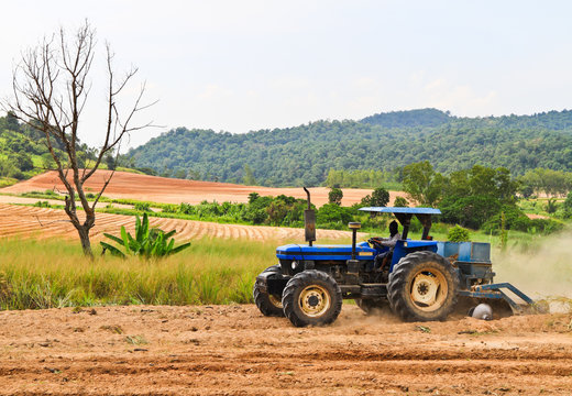 The blue tractor working on a field .