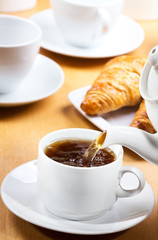 Pouring tea into cup of tea