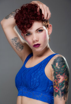 Pretty young woman with tattoos in blue top