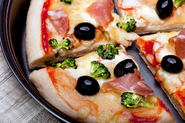 Kawałki pizzy z bekonem, oliwkami i brokułami © Kamila Cyganek