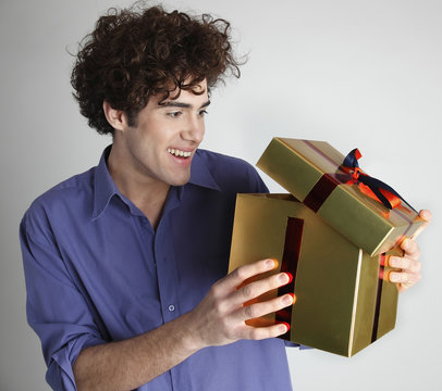 young brown man surprised christmas gold present