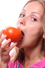 Young woman eating a tomato, isolated