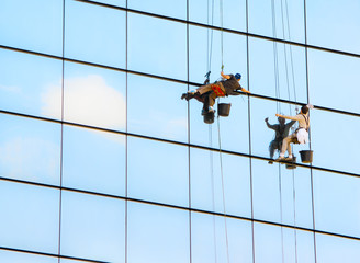 Industrial mountaineering workers wash windows