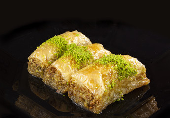 golden baklava dessert isolated on black background