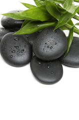 Obraz na płótnie Canvas black zen pebbles and a bamboo leaves
