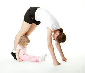 Fototapeta na wymiar Young woman doing sport exercises with her little daughter