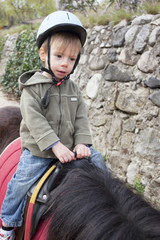 enfant faisant du poney