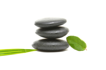 Zen pebbles balance with green leaf