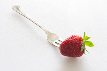 fragola infilzata da una forchetta